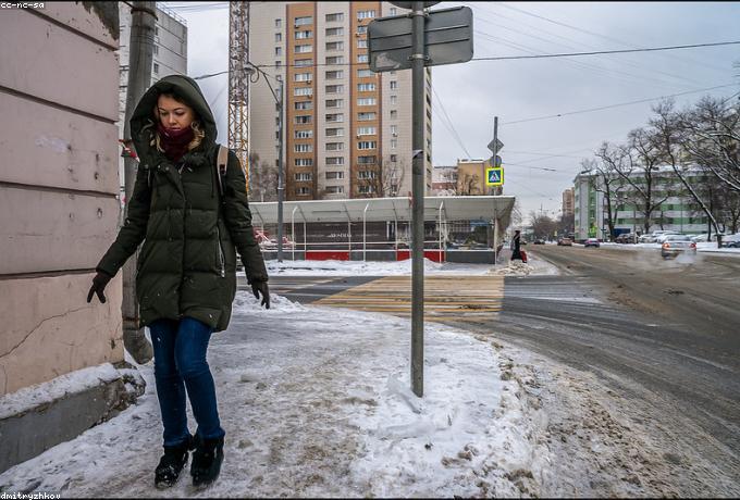 Documentary photo of a woman walking along a wintry main street